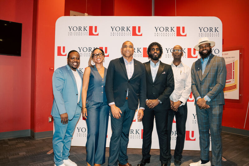 Professionals posing together at a York University event backdrop