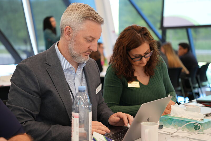 Attendees collaborating over a laptop