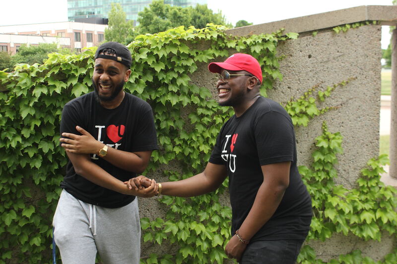 Two attendees greeting each other outdoors