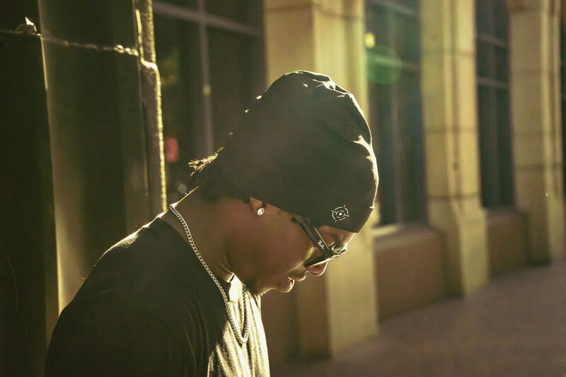 Two models in durags against a sunlit wall