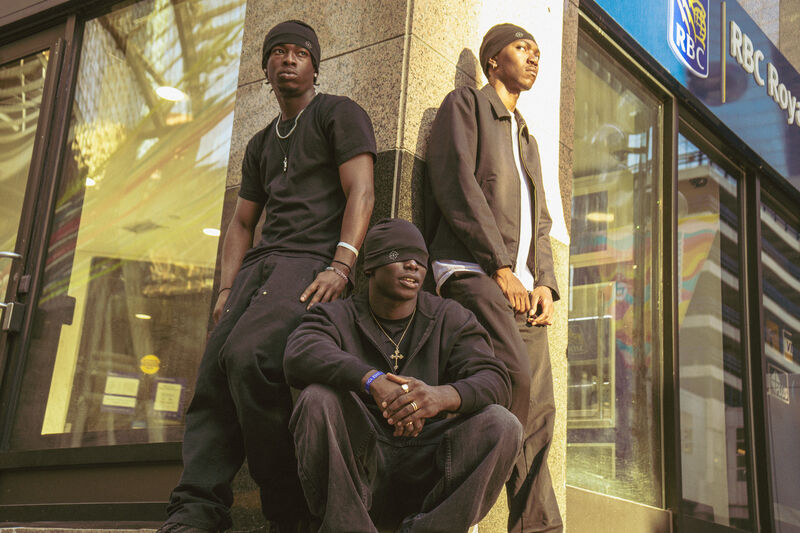 Three models in streetwear outside a storefront